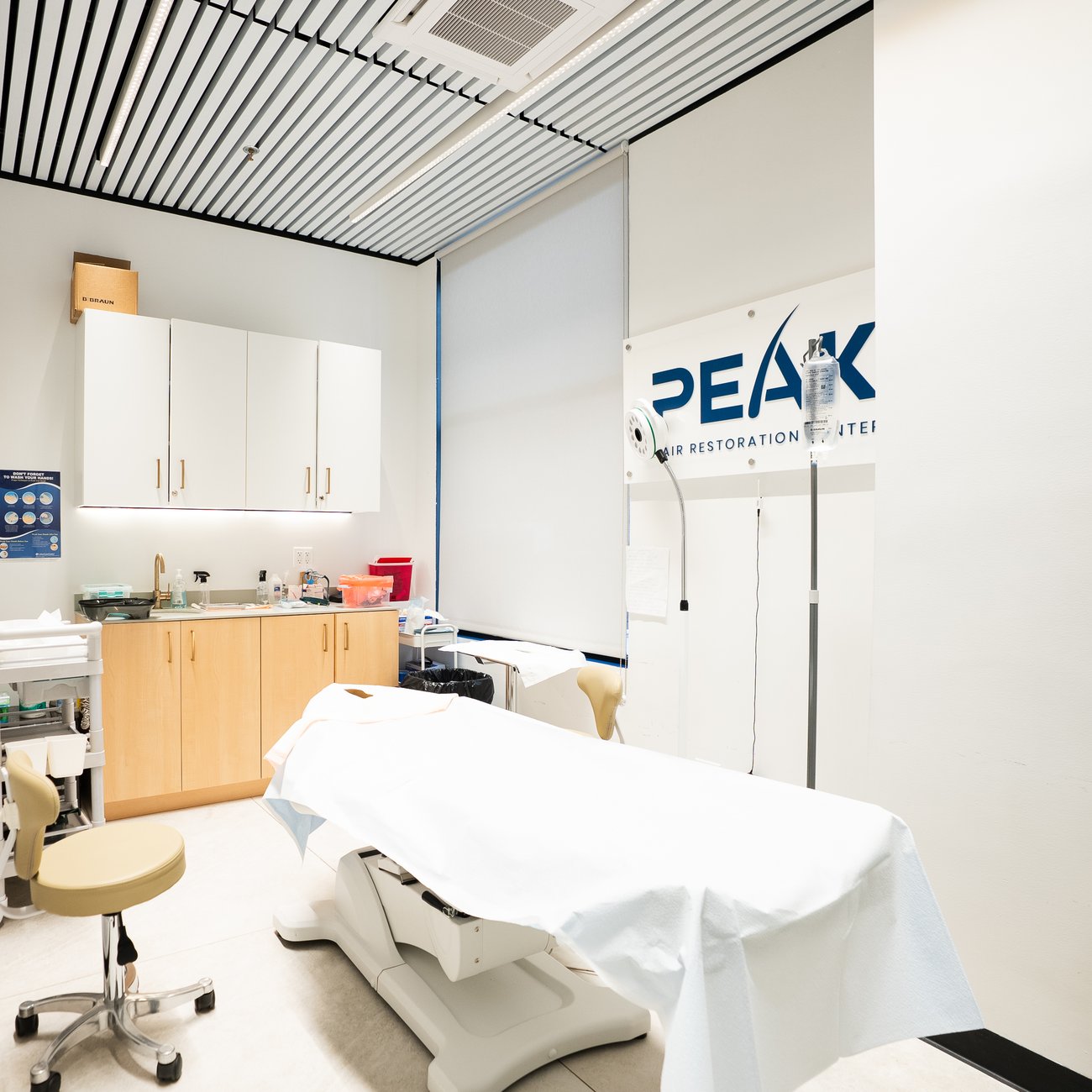 Treatment room with Peak Hair Restoration sign and treatment bed